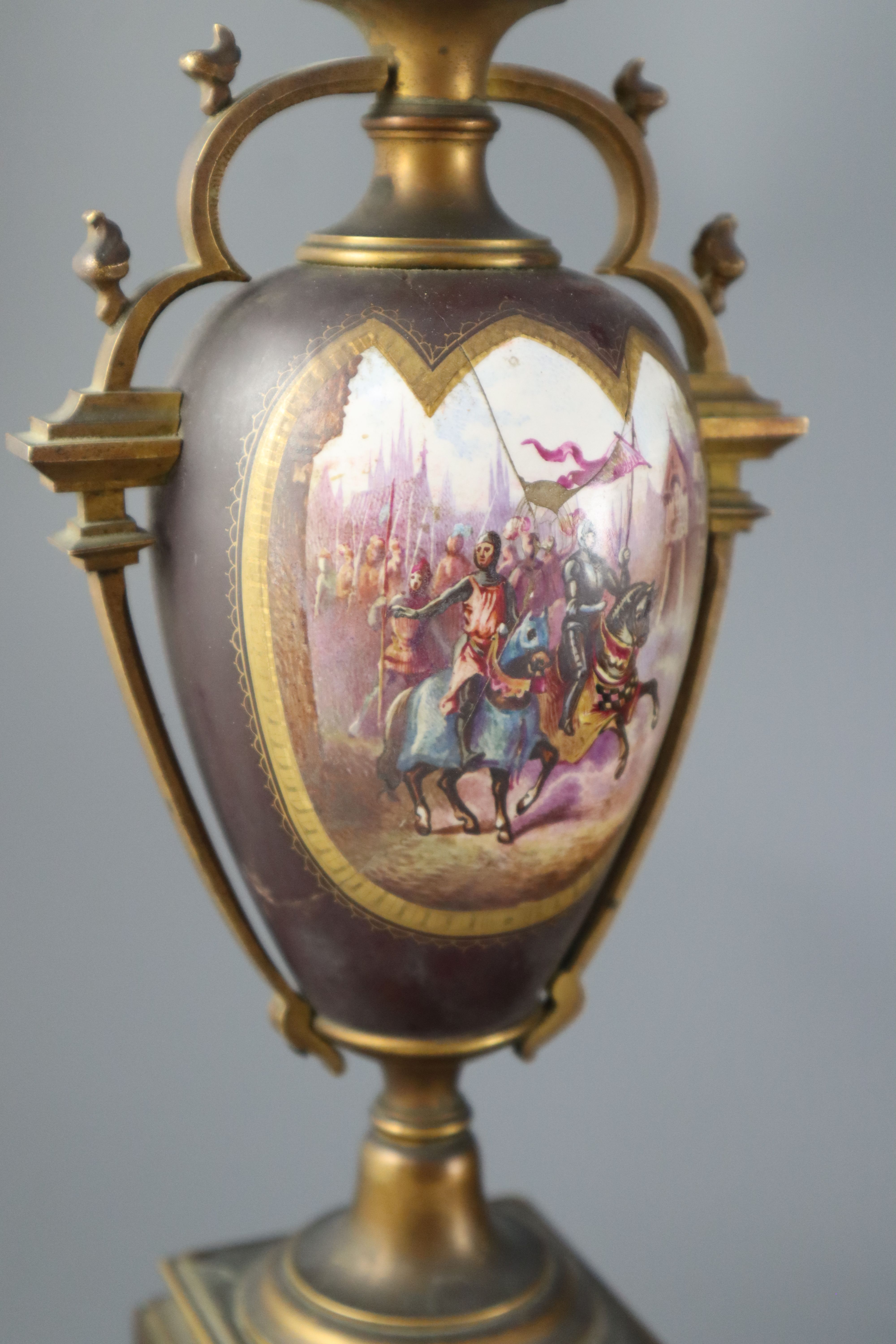 A 19th century French ormolu and enamelled porcelain clock garniture, clock height 13.75in. urns 11.5in. overall on both plinths 17in.